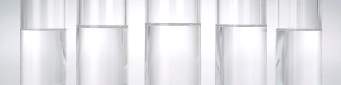 Five beakers in a row with a clear liquid in each one