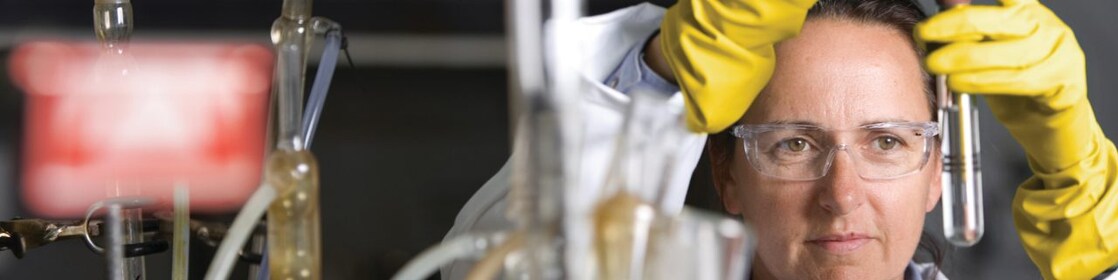 lady in safety goggles conducting a lab experiment