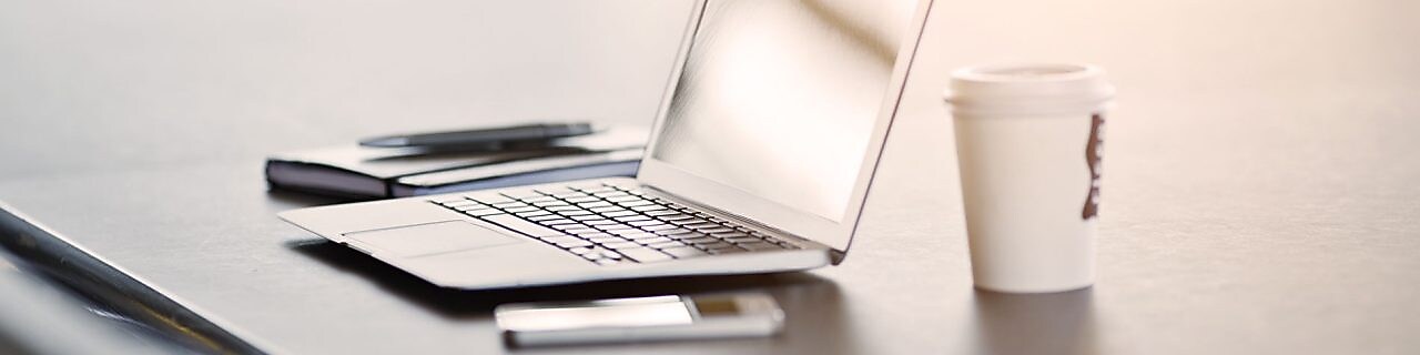 laptop, mobile phone and coffee on a desk