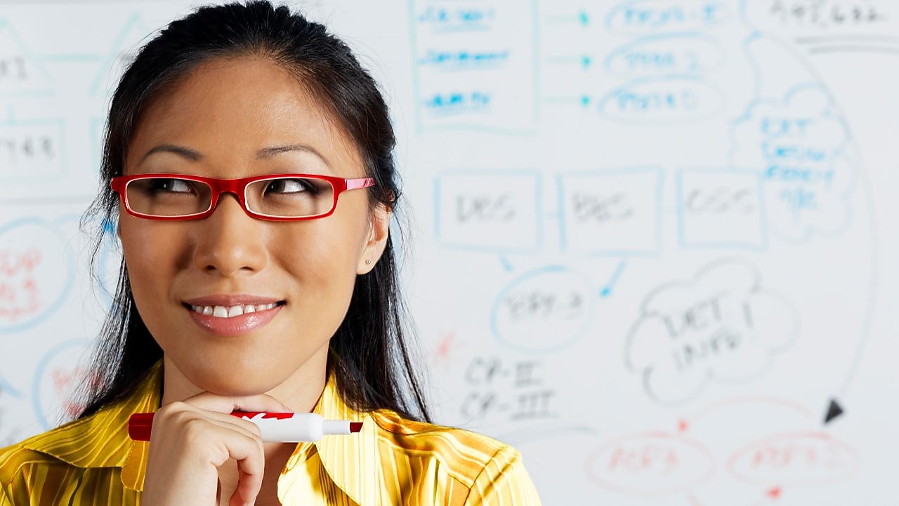 صورة عن قرب لسيدة أعمال آسيوية تبتسم أمام سبورة