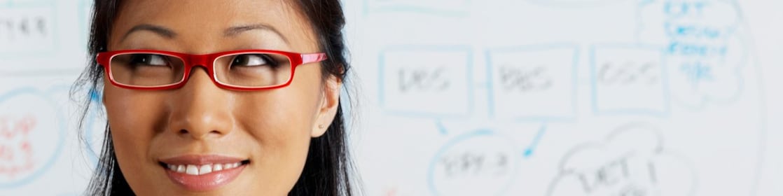 صورة عن قرب لسيدة أعمال آسيوية تبتسم أمام سبورة