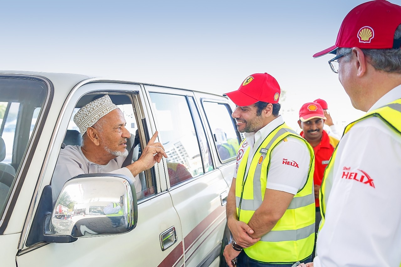 Shell helix attendants talking to a customer in a car
