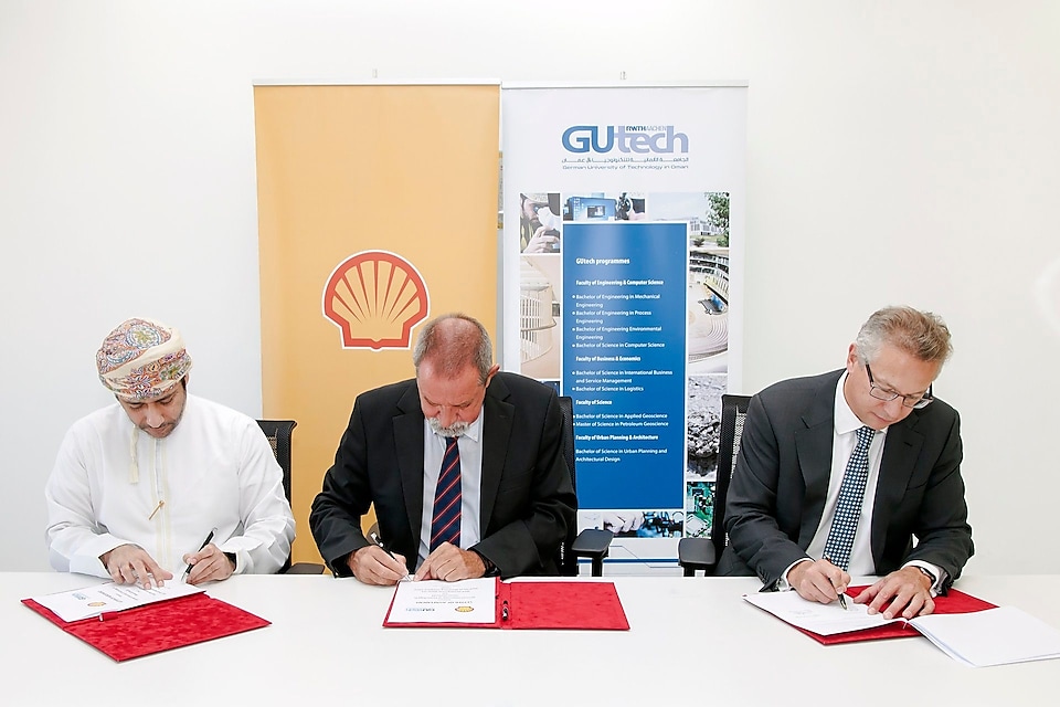 Three men signing an agreement