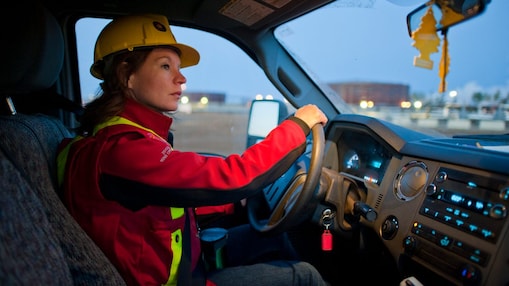 سيدة ترتدي معدات السلامة تقود سيارة 