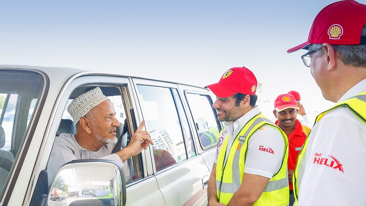 Shell helix attendants talking to a customer in a car