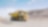 Yellow dumper truck driving through gravel