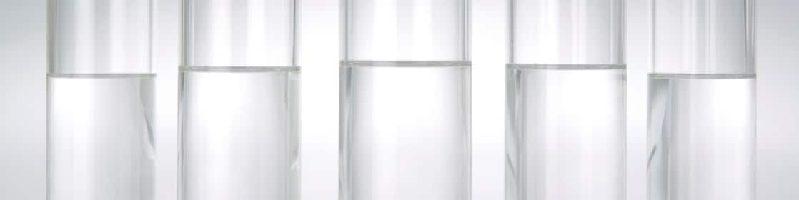Five beakers in a row with a clear liquid in each one