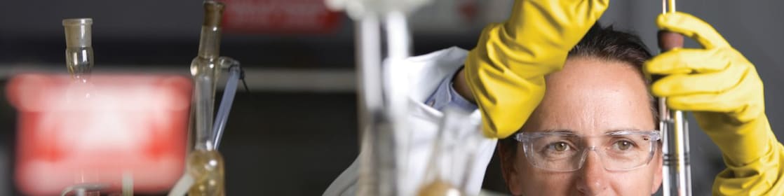 Lady in safety goggles conducting a lab experiment
