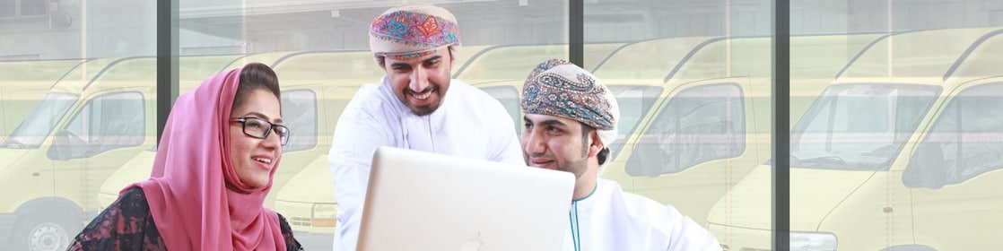 Two mean and a women sitting in front of a laptop