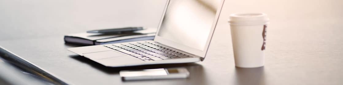 laptop, mobile phone and coffee on a desk