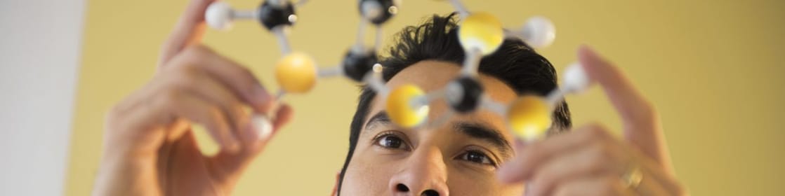 Young man examining molecular model