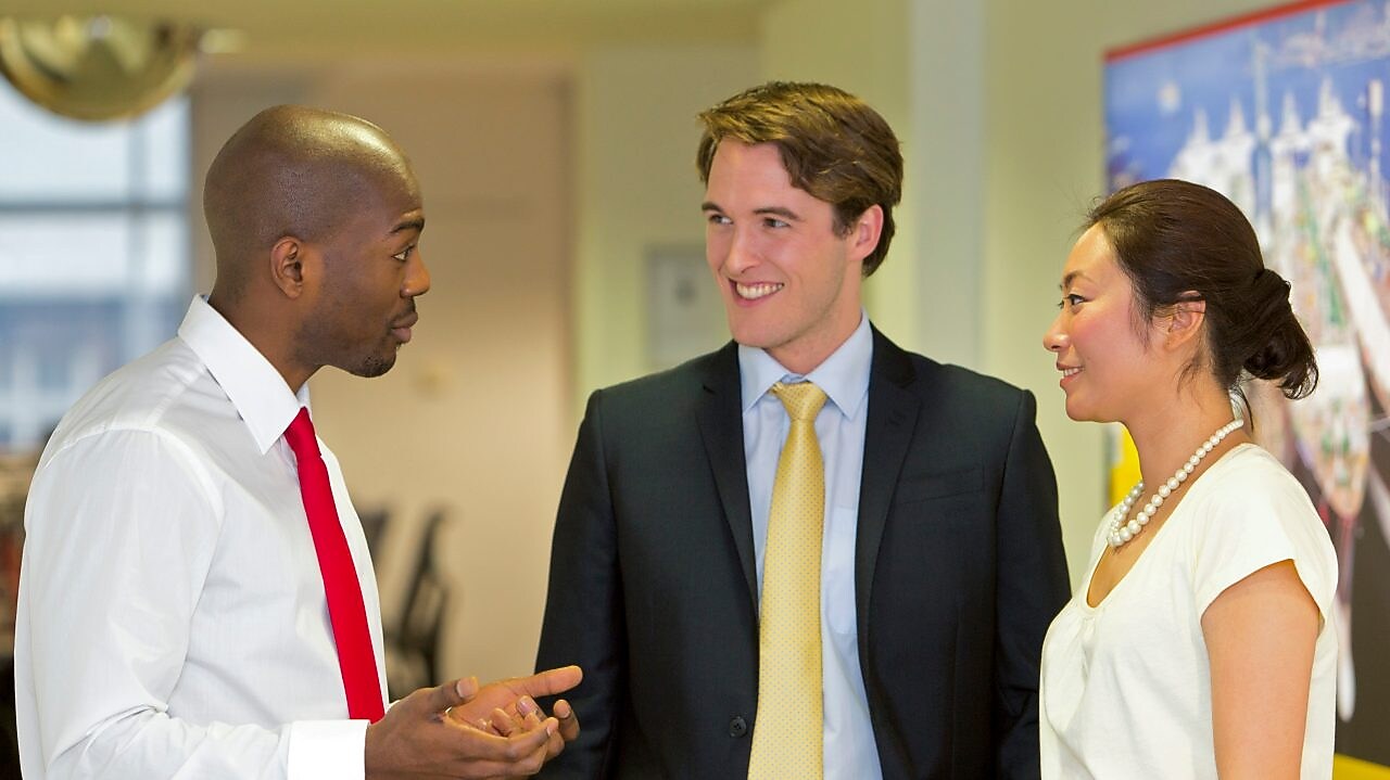 Three employees discussing work