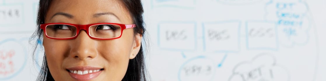 Close up of Asian businesswoman smiling in front of whiteboard