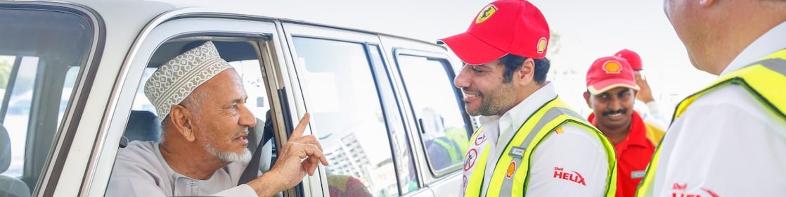 Shell helix attendants talking to a customer in a car