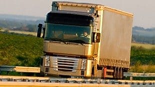 Truck driving on highway, green country background