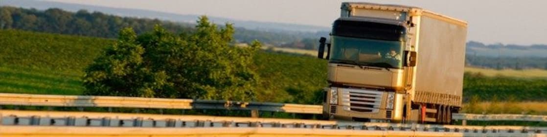 Truck driving on highway, green country background