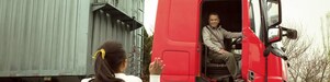 Man in red truck cab with door open waving to his daughter